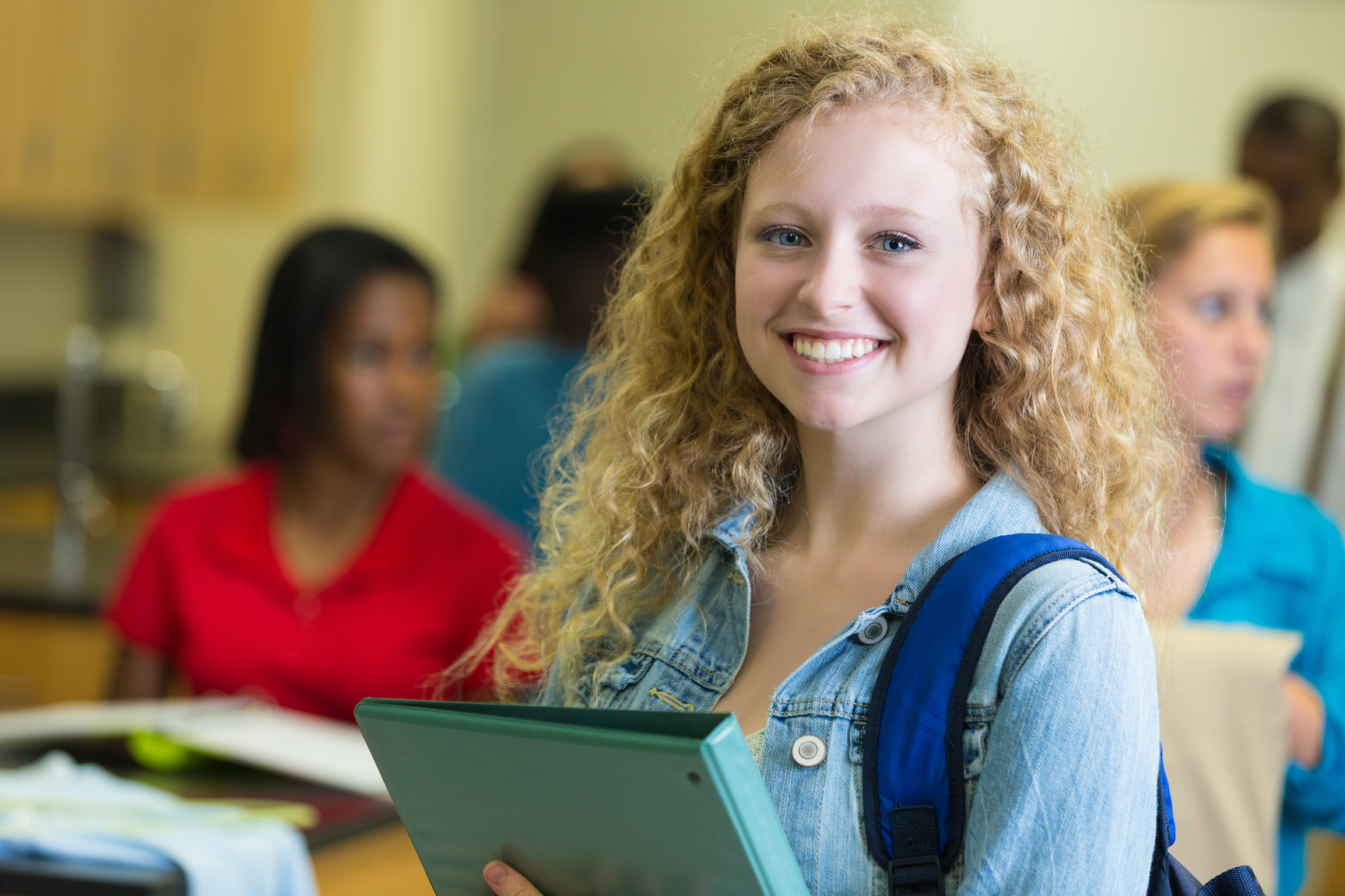 Pretty high schooler walking into class with backpack and notebook